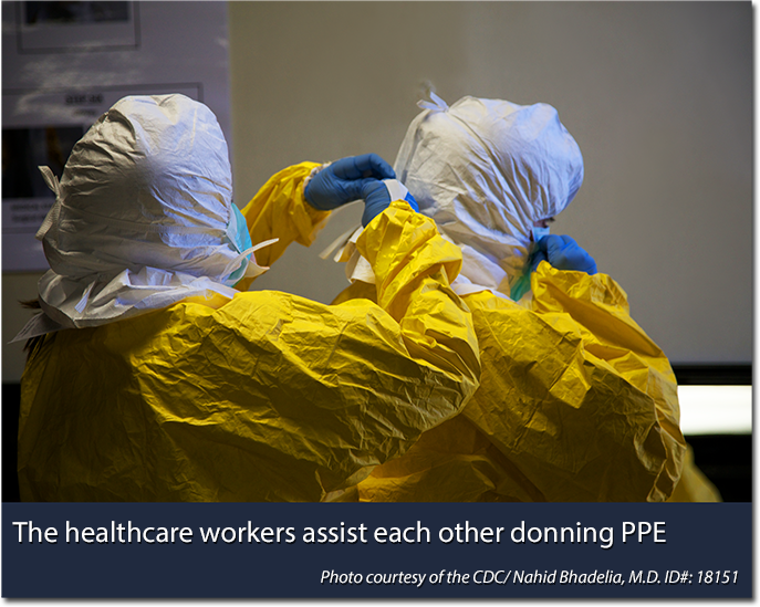 Healthcare workers assisting each other donning PPE. Photo courtesy of the CDC/Nahid Bhadelia, MD ID#: 18151